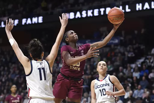 Florida State's Ta'niya Latson goes up for a basket as Connecticut's Lou Lopez-Senechal (11) defends during the second half of an NCAA college basketball game, Sunday, Dec. 18, 2022, in Uncasville, Conn. Latson, the ACC Rookie of the Year, will miss the NCAA Tournament with an undisclosed injury. She averaged 21.3 points and 4.5 rebounds this season. (AP Photo/Jessica Hill, File)