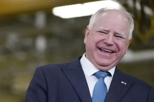 Minnesota Gov. Tim Walz, right, laughs as he stands with Fridley, Minn., Mayor Scott Lund during a visit to the Cummins Power Generation Facility in Fridley, Minn., Monday, April 3, 2023. (AP Photo/Carolyn Kaster, File)