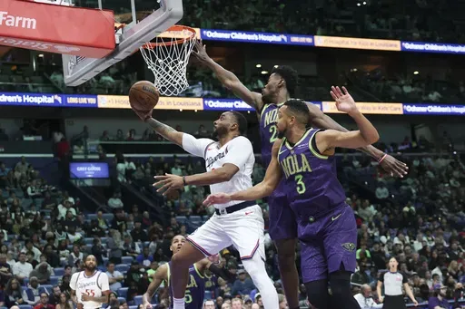Los Angeles Clippers guard Norman Powell attempts a layup against New Orleans Pelicans forward Herbert Jones and guard CJ McCollum in the first half of an NBA basketball game in New Orleans, Monday, Dec. 30, 2024. (AP Photo/Peter Forest)