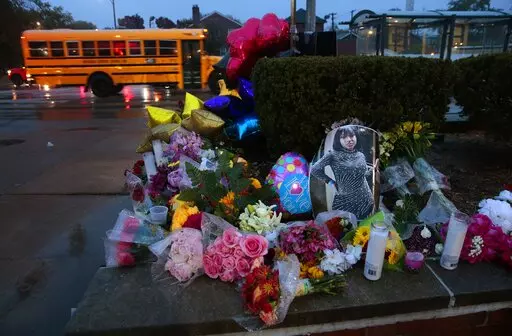 A photo of Alexandria Bell rests at the scene of a growing floral memorial to the victims of a school shooting at Central Visual & Performing Arts High School, Tuesday, Oct. 25, 2022, in St. Louis. Bell and teacher Jean Kuczka were killed, along with the gunman, in Monday's shooting. (Robert Cohen/St. Louis Post-Dispatch via AP)