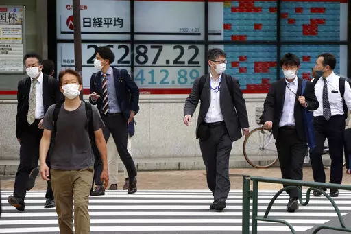 People walk by an electronic stock board of a securities firm in Tokyo, Wednesday, April 27, 2022. Asian shares retreated on Wednesday, echoing a broad decline on Wall Street and driven by worries about how the war in Ukraine may push prices for oil and other commodities higher.(AP Photo/Koji Sasahara)