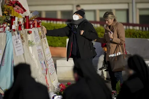 People pray for Pope Francis in front of the Agostino Gemelli Polyclinic, in Rome, Wednesday, March 19, 2025, where the Pontiff is hospitalized since Friday, Feb. 14. (AP Photo/Andrew Medichini)