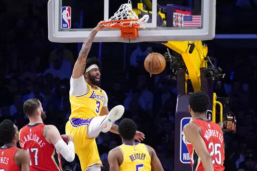 Los Angeles Lakers forward Anthony Davis (3) dunks as New Orleans Pelicans forward Herbert Jones (5), center Jonas Valanciunas (17) and guard Trey Murphy III (25) watch along with guard Malik Beasley (5) during the first half of an NBA basketball game Wednesday, Feb. 15, 2023, in Los Angeles. (AP Photo/Mark J. Terrill)