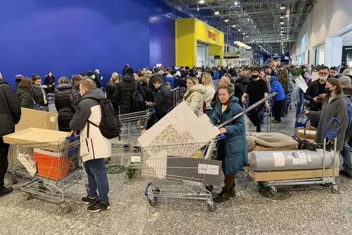 People wait in a line to pay for her purchases at the IKEA store on the outskirts of Moscow, Russia, on March 3, 2022. Furniture and home goods remaining after IKEA exited Russia are being sold off on the Yandex website. (AP Photo, File)