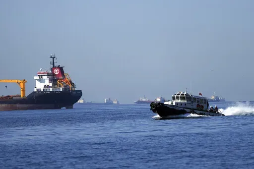 A boat with Russian, Ukrainian, Turkish and U.N. officials heads to inspect cargo ships coming from Ukraine loaded with grain, in the Marmara Sea in Istanbul, Turkey, Saturday, Oct. 1, 2022. The amount of grain leaving Ukraine has dropped even as a U.N.-brokered deal works to keep food flowing to developing nations, with inspections of ships falling to half what they were four months ago and a backlog of vessels growing as Russia's invasion nears the one-year mark. (AP Photo/Khalil Hamra, File)
