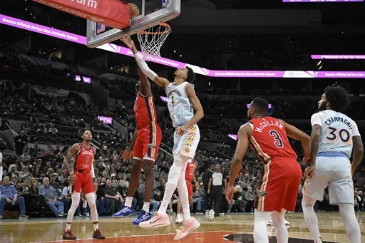San Antonio Spurs' Victor Wembanyama (1) goes to the basket against New Orleans Pelicans' Yves Missi during the first half of an NBA basketball game, Sunday, Dec. 8, 2024, in San Antonio. (AP Photo/Darren Abate)