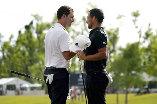 Patrick Cantlay and his teammate Xander Schauffele, right, congratulate each other after their win in the PGA Zurich Classic golf tournament at TPC Louisiana in Avondale, La., Sunday, April 24, 2022. (AP Photo/Gerald Herbert)