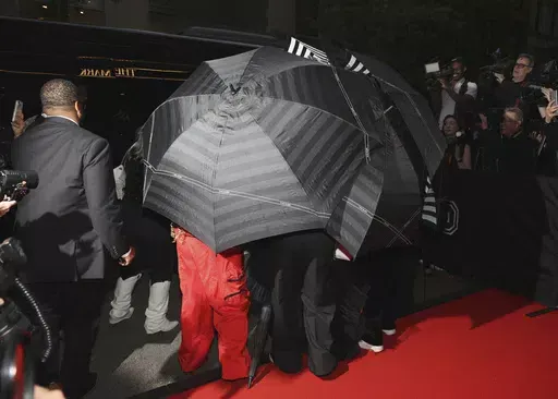 Umbrellas cover a person as they depart The Mark Hotel prior to attending The Metropolitan Museum of Art's Costume Institute benefit gala celebrating the opening of "Sleeping Beauties: Reawakening Fashion" on Monday, May 6, 2024, in New York. (Photo by CJ Rivera/Invision/AP)