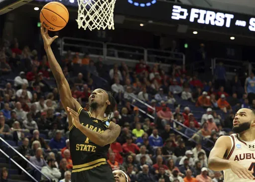 CORRECTS YEAR - Alabama State's Amarr Knox (1) shoots past Auburn's Johni Broome, right, during the second half in the first round of the NCAA college basketball tournament in Lexington, Ky., Thursday, March 20, 2025. (AP Photo/James Crisp)