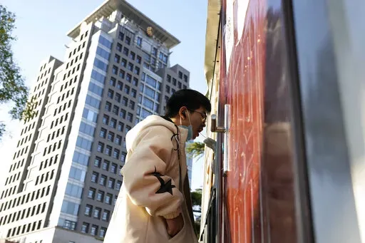 A man gets swabbed for COVID test near a building of the Peking University in Beijing, Wednesday, Nov. 16, 2022. Chinese authorities locked down the major university in Beijing on Wednesday after finding one COVID-19 case as they stick to a "zero-COVID" approach despite growing public discontent. (AP Photo/Ng Han Guan)