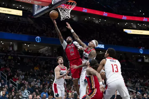 New Orleans Pelicans forward Brandon Ingram (14) shoots a layup in front of Washington Wizards forward Kyle Kuzma (33) during the first half of an NBA basketball game, Wednesday, Dec. 13, 2023, in Washington. (AP Photo/Stephanie Scarbrough)