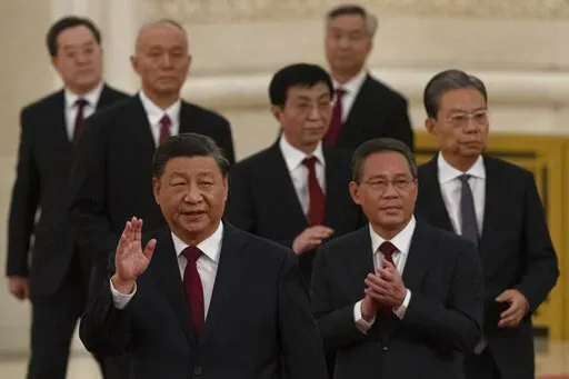 New members of the Politburo Standing Committee, front to back, President Xi Jinping, Li Qiang, Zhao Leji, Wang Huning, Cai Qi, Ding Xuexiang, and Li Xi arrive at the Great Hall of the People in Beijing on Oct. 23, 2022. The world faces the prospect of more tension with China over trade, security and human rights after Xi Jinping awarded himself a third five-year term on Oct. 23, 2022 as leader of the ruling Communist Party. (AP Photo/Ng Han Guan, File)