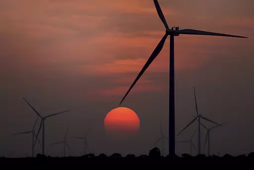 The sun sets at wind farm in McCook, Texas during a heat wave on July 20, 2022. Both sides of the political spectrum have their say about ESG: It’s either just a label that costs more, or it’s saving the world. Environmental, social and corporate governance criteria are factors for evaluating investments and companies, but have those criteria created any change? (Delcia Lopez/The Monitor via AP, File)