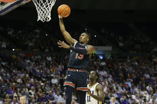 Auburn guard Miles Kelly (13) gets past LSU forward Corey Chest (11) for a breakaway layup during an NCAA college basketball game in Baton Rouge, La., Wednesday, Jan. 29, 2025. (AP Photo/Peter Forest)