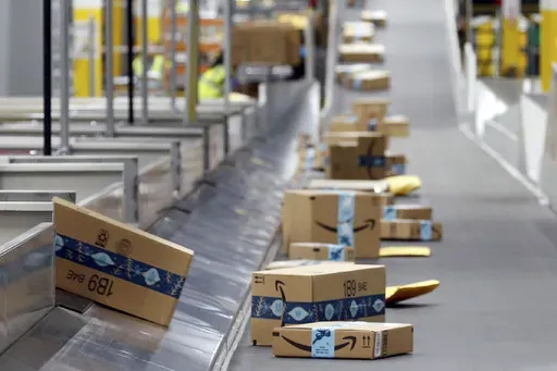 Amazon packages move along a conveyor at an Amazon warehouse facility, Dec. 17, 2019, in Goodyear, Ariz. (AP Photo/Ross D. Franklin, File)