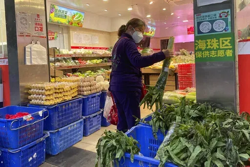 A woman shops in a reopened grocery store in the district of Haizhu as pandemic restrictions are eased in southern China's Guangzhou province, Thursday, Dec. 1, 2022. More Chinese cities eased some anti-virus restrictions as police patrolled their streets to head off protests Thursday while the ruling Communist Party prepared for the high-profile funeral of late leader Jiang Zemin. (AP Photo)