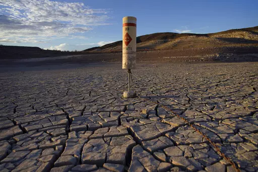 A buoy sits high and dry on cracked earth previously under the waters of Lake Mead at the Lake Mead National Recreation Area near Boulder City, Nev., on June 28, 2022. Living with less water in the U.S. Southwest is the focus for a conference starting Wednesday, Dec. 14, 2022, in Las Vegas, about the drought-stricken and overpromised Colorado River. (AP Photo/John Locher, File)