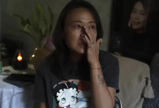 Zhang Peiyi, a Shanghai resident, tears up during an interview at her home in Shanghai on July 31, 2024. (AP Photo/Ng Han Guan)