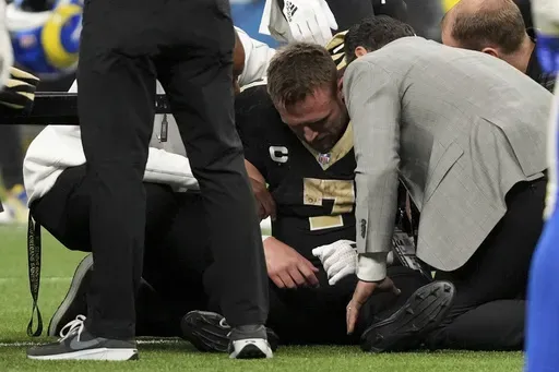 New Orleans Saints tight end Taysom Hill (7) goes down with an injury during the second half of an NFL football game against the Los Angeles Rams, Sunday, Dec. 1, 2024, in New Orleans. (AP Photo/Gerald Herbert)