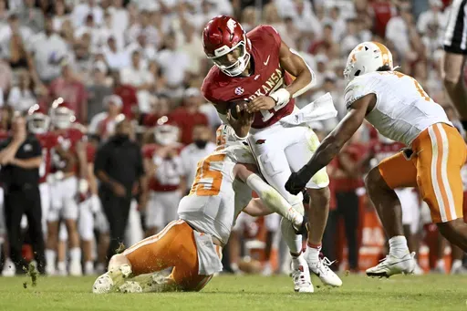 Arkansas quarterback Taylen Green (10) is tackled by Tennessee defenders Edrees Farooq, left, and Arion Carter, right, during the second half of an NCAA college football game Saturday, Oct. 5, 2024, in Fayetteville, Ark. (AP Photo/Michael Woods)