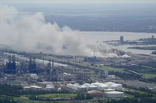 A chemical fire burns at a facility during the aftermath of Hurricane Laura, Aug. 27, 2020, near Lake Charles, La. The Securities and Exchange Commission moved closer Friday, June 17, 2022, to a final rule that would dramatically change what public companies tell shareholders about climate change. Companies would also have to disclose risks related to the physical impact of storms, drought and higher temperatures brought on by global warming.  (AP Photo/David J. Phillip, File)