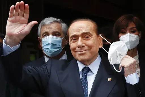 Former Italian Premier Silvio Berlusconi waves to reporters as he arrives at the Chamber of Deputies to meet Mario Draghi, in Rome, on Feb. 9, 2021. Former premier Silvio Berlusconi has bowed out of Italy’s presidential election set for next week. Berlusconi, 85, said in a statement on Saturday that he had decided to “take another step on the path of national responsibility.” The media mogul  insisted he had nailed down enough voters to become head of state, but he asked his supporters no
