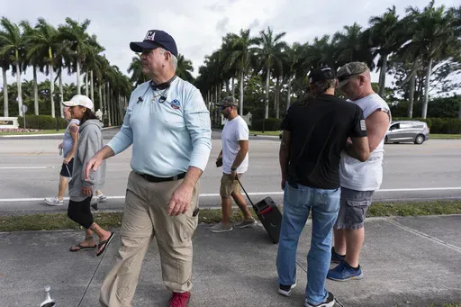 Alan Mentser, in foreground at left, from West Palm Beach, Fla., joins other supporters of President Donald Trump outside the Trump International Golf Club, Saturday, March 29, 2025, in West Palm Beach. (AP Photo/Manuel Balce Ceneta)