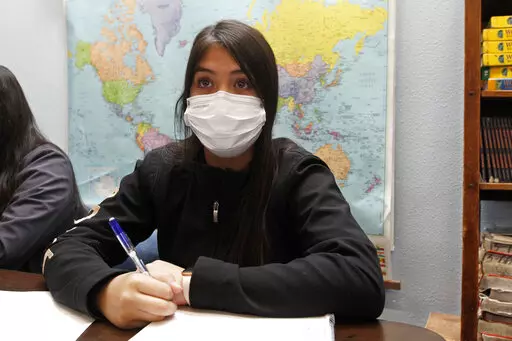 Jazmin Cazares, 14, takes notes as teacher Wendy Leighton discusses the Salem witch trials with her students at Monte del Sol Charter School, Friday, Dec. 3, 2021, in Santa Fe, N.M. Leighton is one of dozens of educators who helped draft state's proposed changes to the social studies curriculum, including adding the Sept. 11 attacks and the history of LGBTQ rights. It would increase the focus on ethnic studies in a state where 49 percent of the population is Hispanic, and 11 precent is Indigenou