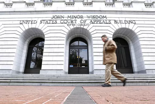 A man walks in front of the 5th U.S. Circuit Court of Appeals on Jan. 7, 2015, in New Orleans. A federal appeals court cleared the way Friday, Aug. 19, 2022, for a lawsuit to proceed against guards and officials at a privately run north Louisiana jail where an inmate died with a fractured skull in 2015. The lawsuit includes allegations that guards at Monroe's Richwood Correctional Center sometimes beat and pepper-sprayed handcuffed prisoners in an area where there were no security cameras. (AP P