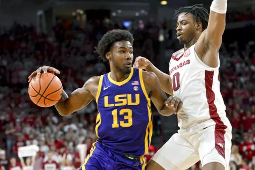 LSU forward Tari Eason (13) tries to drive past Arkansas guard Stanley Umude (0) during the second half of an NCAA college basketball game Wednesday, March 2, 2022, in Fayetteville, Ark. (AP Photo/Michael Woods)