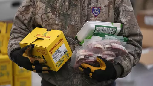 A Utah Food Bank volunteer carries groceries for the needy at a mobile food pantry distribution site Wednesday, Dec. 21, 2022, in Salt Lake City. Supporting nonprofits on GivingTuesday this year could have a bigger impact than usual as nonprofits and industry groups say donations so far are down compared with previous years. Many organizations will be looking to make up the difference on GivingTuesday, which is the Tuesday after Thanksgiving, Nov. 28, 2023. (AP Photo/Rick Bowmer, File)
