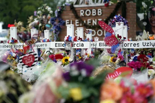 Crosses are surrounded by flowers and other items at a memorial, June 9, 2022, for the victims of a shooting at Robb Elementary School in Uvalde, Texas. (AP Photo/Eric Gay, File)