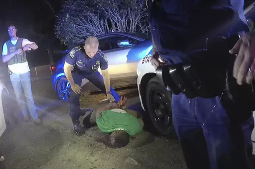 FILE — This image taken from video from Louisiana state trooper Lt. John Clary's body-worn camera shows trooper Kory York standing over Ronald Greene on his stomach on May 10, 2019, outside of Monroe, La. On Monday, Dec. 18, 2023, a state police spokesman said Clary, the ranking trooper at the scene of Greene's in-custody death, will return to active duty. (Lt. John Clary/Louisiana State Police via AP, File)