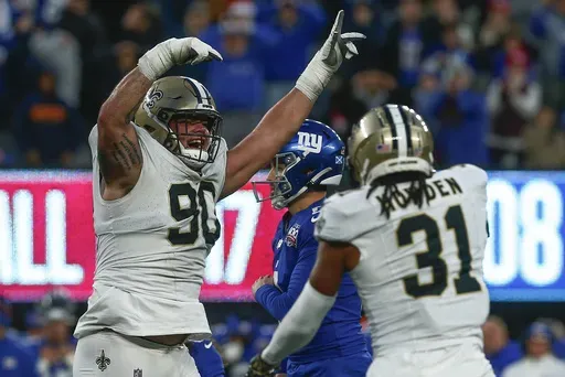 New Orleans Saints defensive tackle Bryan Bresee (90) and safety Jordan Howden (31) celebrate after the New York Giants missed a field goal late in the fourth quarter of an NFL football game, Sunday, Dec. 8, 2024, in East Rutherford, N.J. (AP Photo/John Munson)