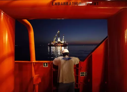 Wilson Ruiz, a crew member of the Joe Griffin, looks out at the oil slick at the site of the BP Deepwater Horizon offshore oil rig collapse in the Gulf of Mexico on May 6, 2010. The Biden administration has tightened offshore oil drilling safety regulations, including rules regarding the use of “blowout preventer” devices on offshore oil and gas drilling rigs. Planned changes announced last fall were finalized Tuesday, Aug. 22, 2023 — more than 13 years after the BP Deepwater Horizon disas