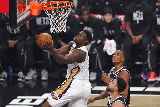 New Orleans Pelicans' Zion Williamson, left, drives past Brooklyn Nets' Nic Claxton, top right, and Ben Simmons during the first half of an NBA basketball game Wednesday, Oct. 19, 2022 in New York. (AP Photo/Frank Franklin II)