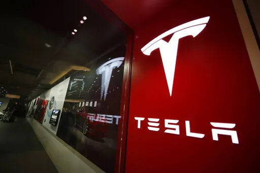 A sign bearing the company logo outside a Tesla store in Cherry Creek Mall in Denver, Feb. 9, 2019. Elon Musk has sold 4.4 million shares of  Tesla stock worth roughly $4 billion, most likely to help fund his purchase of Twitter. (AP Photo/David Zalubowski, File)