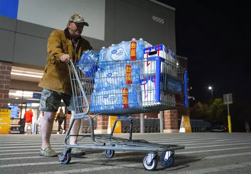 John Beezley, of Bonham, carts out several cases of water after learning that a boil water notice was issued for the entire city of Houston on Sunday, Nov. 27, 2022, at Walmart on S. Post Oak Road in Houston. Beezley just arrived in town with his wife, who is undergoing treatment starting tomorrow at M.D. Anderson Cancer Center, where they are staying in a camping trailer. They turned on the television after settling in and saw that a boil water notice had been issued. Beezley decided to go out 