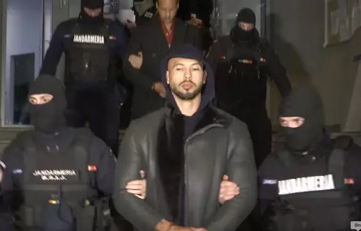 In this grab taken from video released by Observator Antena 1, Social Media personality Andrew Tate is led away by police, in the Ilfov area, north of Bucharest, Romania, Thursday, Dec. 29, 2022. Romanian news outlets are reporting that divisive social media personality Andrew Tate has been arrested on charges of human trafficking and rape. The reports say Tate and his brother Tristan were detained late Thursday. Romania’s anti-organized crime agency said two British citizens and two Romanians