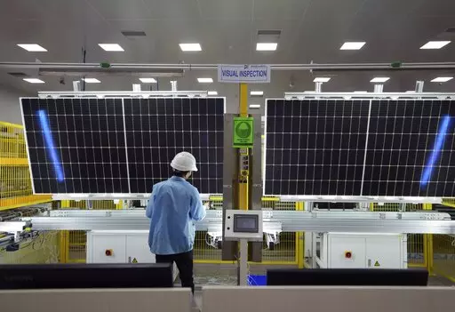 A worker inspects solar panels at Premier Energies Solar on the outskirts of Hyderabad, India, Wednesday, Jan. 25, 2023. Solar developers in India fear that a tax meant to encourage Indian manufacture of solar components will slow down the installation of solar power this year. (AP Photo/Mahesh Kumar A.)