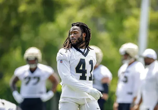 New Orleans Saints running back Alvin Kamara (41) takes off his helmet during the team's NFL mini-camp football practice in Metairie, La., June 11, 2024. Kamara reported for training camp Tuesday, July 23, 2024, in Irvine, California, after leaving the team's June minicamp early because of an ongoing contract dispute. (Sophia Germer/The Times-Picayune/The New Orleans Advocate via AP, File)