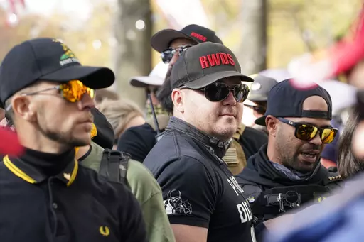People identifying themselves as members of the Proud Boys join supporters of President Donald Trump for pro-Trump marches, Nov. 14, 2020, in Washington. Two supporter in the center are wearing hats with red lettering that read “RWDS,” which is short for “Right Wing Death Squad.” The gunman who killed eight people on Saturday, May 6, 2023, at a Dallas-area mall was wearing a “RWDS” patch. The phrase has been embraced in recent years by far-right extremists who glorify violence agains