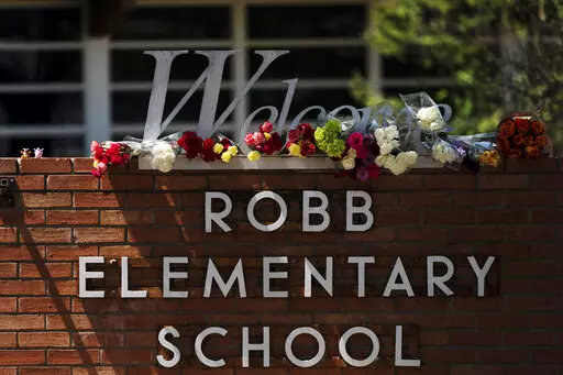 Flowers are placed around a welcome sign outside Robb Elementary School in Uvalde, Texas, Wednesday, May 25, 2022, to honor the victims killed in a shooting at the school a day earlier. In the aftermath of the elementary school massacre in Uvalde, Texas, schools around the U.S. have brought in additional security staff and restricted visitors as they've dealt with a new rash of copycat threats. (AP Photo/Jae C. Hong, File)