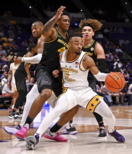 LSU guard Justice Hill (3) moves the ball around Missouri guard DeAndre Gholston (4) and forward Noah Carter during an NCAA college basketball game Wednesday, March 1, 2023, in Baton Rouge, La. (Hilary Scheinuk/The Advocate via AP)