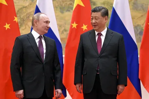Chinese President Xi Jinping, right, and Russian President Vladimir Putin talk to each other during their meeting in Beijing, Feb. 4, 2022. China is the only friend that might help Russia blunt the impact of economic sanctions over its invasion of Ukraine, but President Xi Jinping’s government is giving no sign it might be willing to risk its own access to U.S. and European markets by doing too much. (Alexei Druzhinin, Sputnik, Kremlin Pool Photo via AP, File)