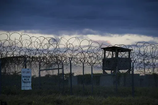 In this photo reviewed by U.S. military officials, the sun sets behind the closed Camp X-Ray detention facility, on April 17, 2019, in Guantanamo Bay Naval Base, Cuba. The Biden administration has been quietly laying the groundwork to release prisoners from the Guantanamo Bay detention center and at least move closer to being able to shut it down. (AP Photo/Alex Brandon, File)
