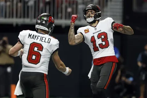 Tampa Bay Buccaneers wide receiver Mike Evans (13) celebrates with quarterback Baker Mayfield (6) after scoring against the Atlanta Falcons during the first half of an NFL football game Thursday, Oct. 3, 2024, in Atlanta. (AP Photo/Butch Dill)