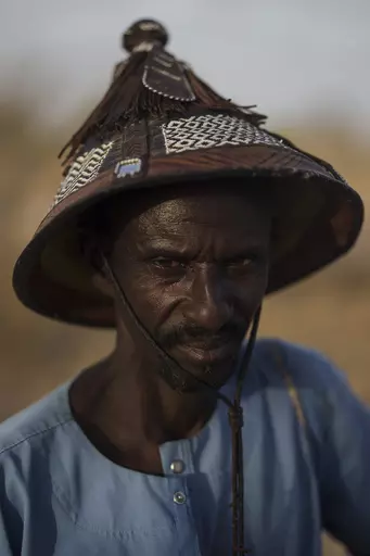 Amadou Altine Ndiaye stands for a portrait in the village of Yawara Dieri, in the Matam region of Senegal, Saturday, April 15, 2023. The 48 year-old herder, who had cattle and sheep present at his birth, says that he was born into pastoralism, and since then he has known only that. For Ndiaye, who began tending to his family's flock when he was just 8 years old, his profession is also an inherited tradition. "It's a source of pride. ... We Fulanis would be lost if we had to change our method of 