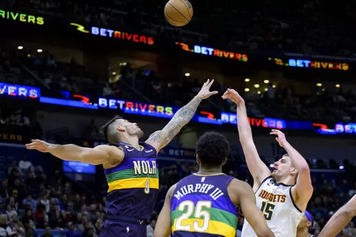 Denver Nuggets center Nikola Jokic (15) shoots over New Orleans Pelicans center Willy Hernangomez (9) in the second half of an NBA basketball game in New Orleans, Tuesday, Jan. 24, 2023. (AP Photo/Matthew Hinton)