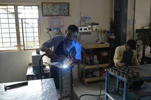 A worker welds a steel chassis at a factory in a suburb of Bengaluru, India, Thursday, Feb. 27, 2025. (AP Photo/Aijaz Rahi)